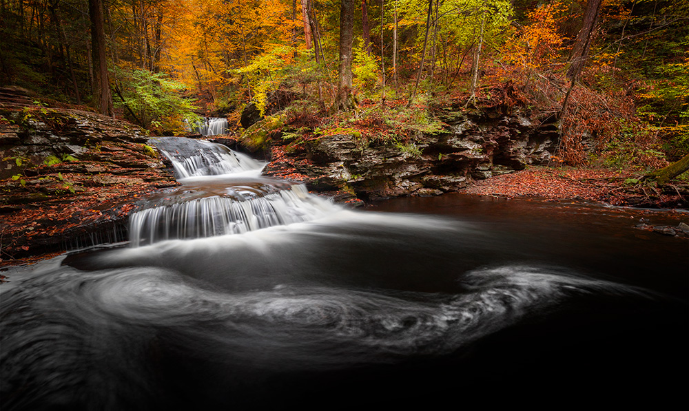 Taking long-exposure photos of foam patterns on a pond surface is predictably unpredictable process. It’s impossible to know beforehand what the result of those 30 seconds would be. You can only take multiple shots and then torture yourself trying to determine the most aesthetically pleasing. I took a few dozen pictures of this cascade in Ricketts Glen Park and eventually ended up with just two options to pick out from. The foam patterns on the other shot clearly resembled X-rays of the male reproductive system. Gosh, it was a tough choice to make! And I’m still puzzled why I ultimately ended up with this one.